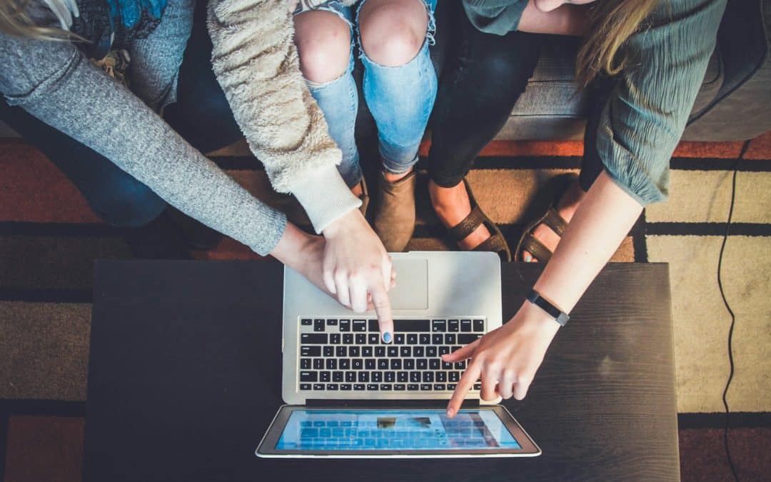 three person pointing the silver laptop computer